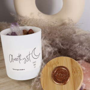 Elegante kaars in wit glazen pot met amethist en rozen.