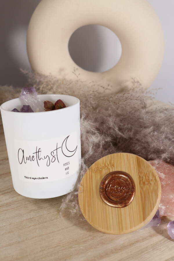 Elegante kaars in wit glazen pot met amethist en rozen.